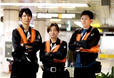 地下鉄の駅で男性作業者3人が腕組みをしている