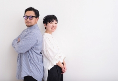 男女が背中合わせでこちらを見ている