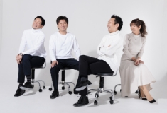 男性3人と女性1人が椅子に座って談笑している