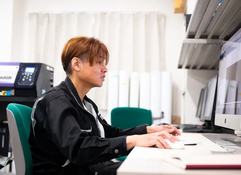 工場長がパソコンで作業をしている様子